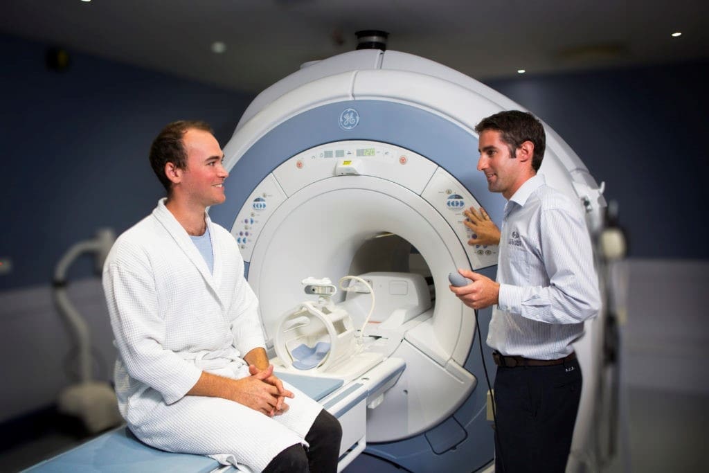 Patient on MRI machine and radiologist